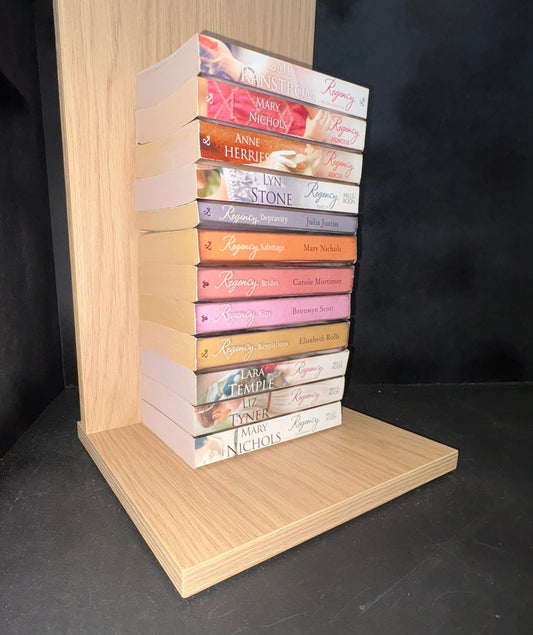 Row of books with colorful spines on a wooden shelf against a dark background