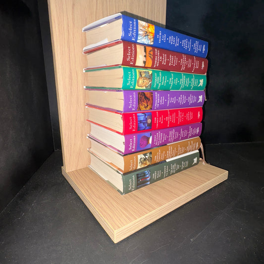 Set of books on a wooden shelf against a dark background